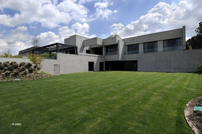 Otra vista en perspectiva desde uno de los jardines de la propiedad Casa residencial de concreto minimalista en España