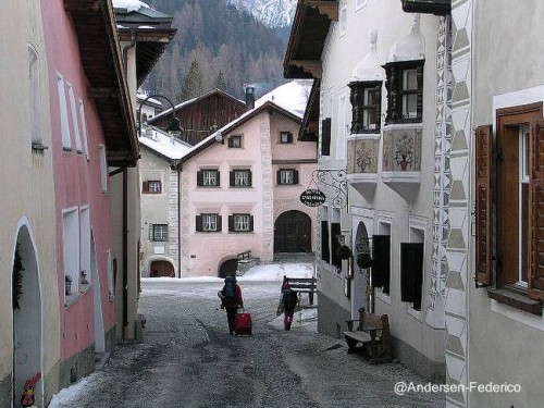 Calle angosta de pueblo en los alpes suizos con casas rústicas con fachadas intervenidas Fachadas decoradas en casas rústicas
