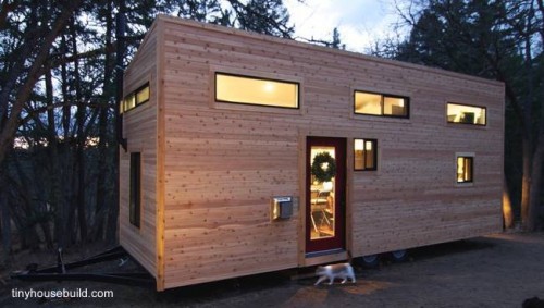 Vista exterior de la pequeña casa de madera sobre trailer