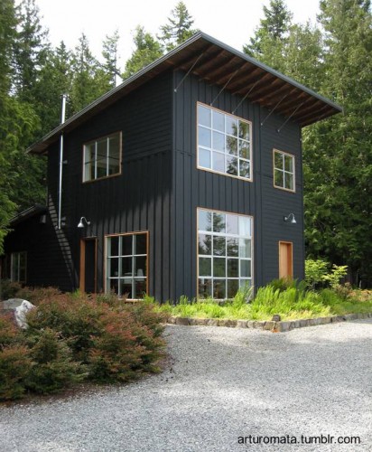 Una bonita casa de madera cuadrada y oscurecida en el bosque